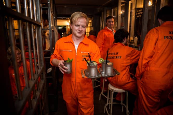 An inmate delivering drinks in Alcotraz, one of the best immersive experiences in London