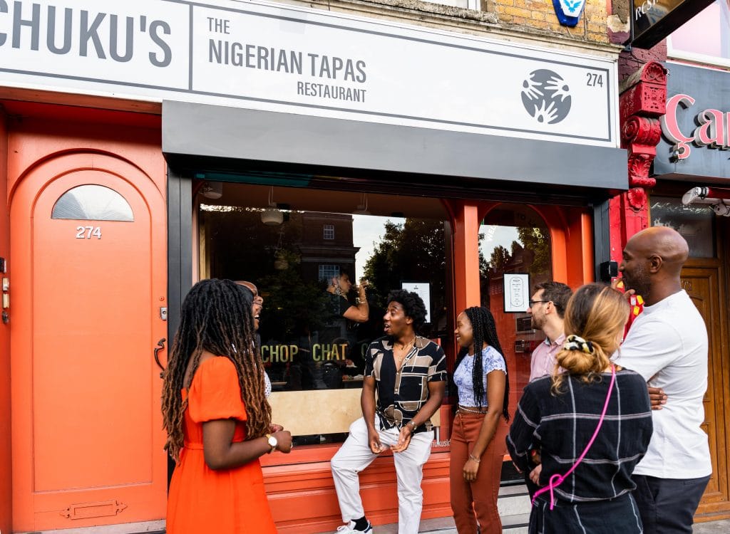 a group of people waiting outside Chuku's restaurant in Tottenham