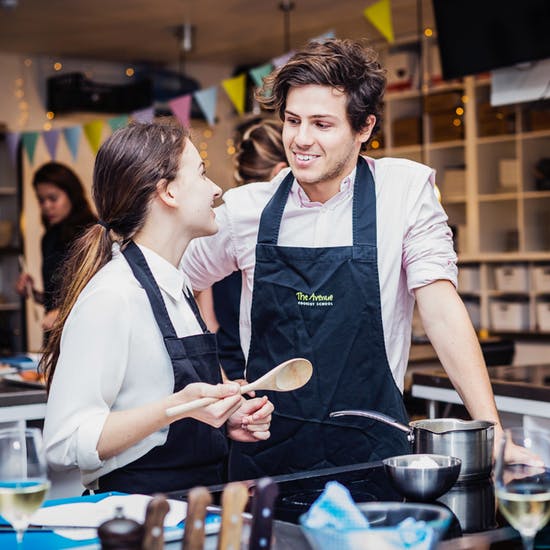 Two people cooking at the Avenue Cookery School in London 