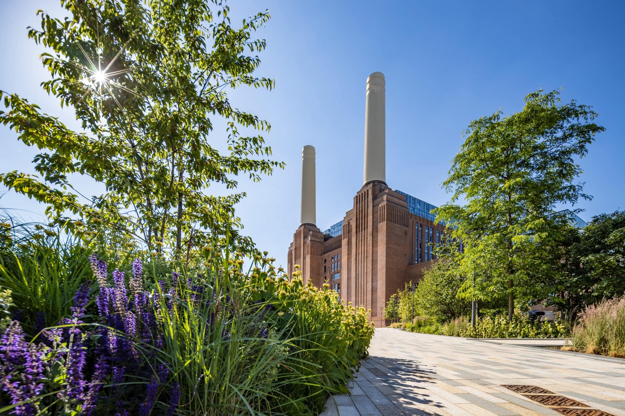 The exterior of Battersea Power Station, with some flowering plants in the foreground