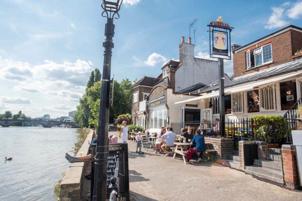 people enjoying a sunny day outside The Bell & Crown, one of London's riverside pubs