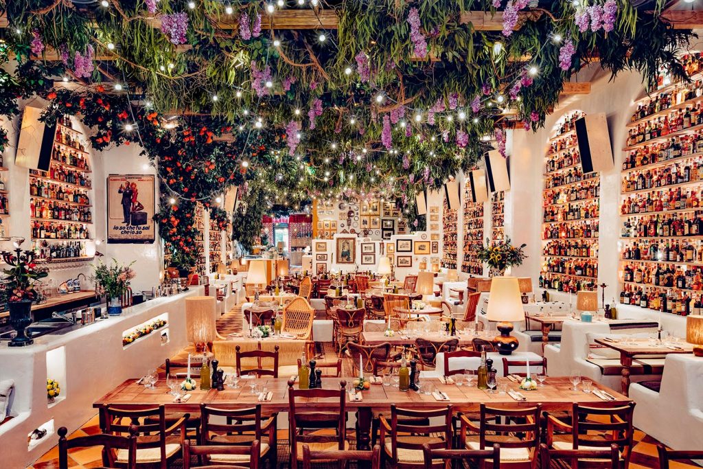 Interior shot of Circolo Popolare, one of London's prettiest restaurants, featuring twinkling lights and bottles of alcohol.