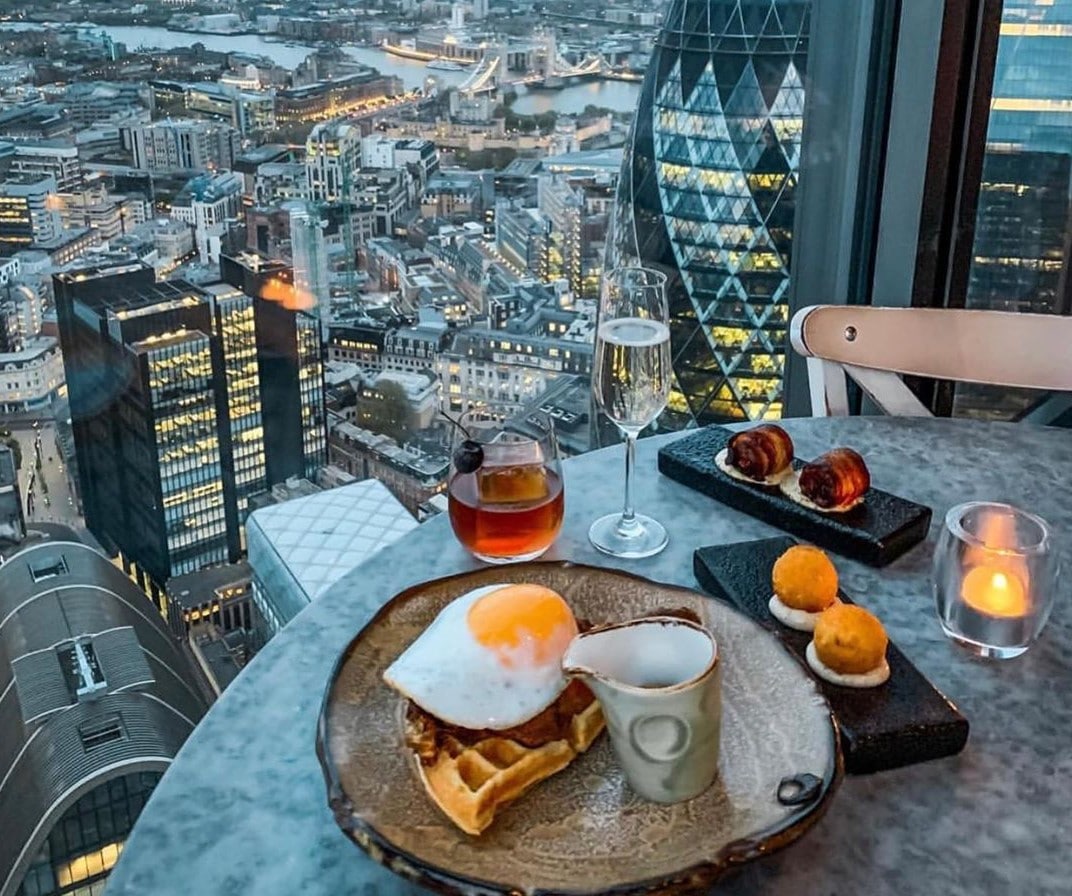 A plate of Duck and Waffle being served at the namesake restaurant at sunset