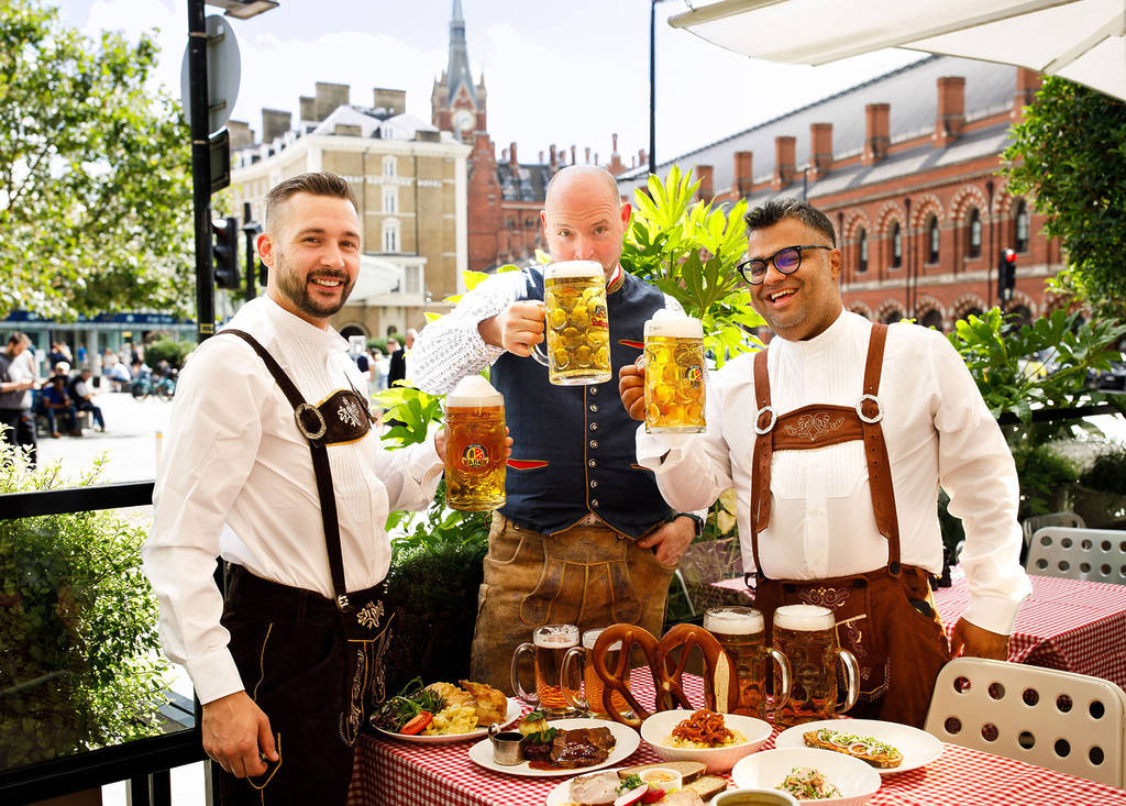 A group of men raising glasses of steins of beer at the German Gymnasium in King's Cross, one of the best places for Oktoberfest