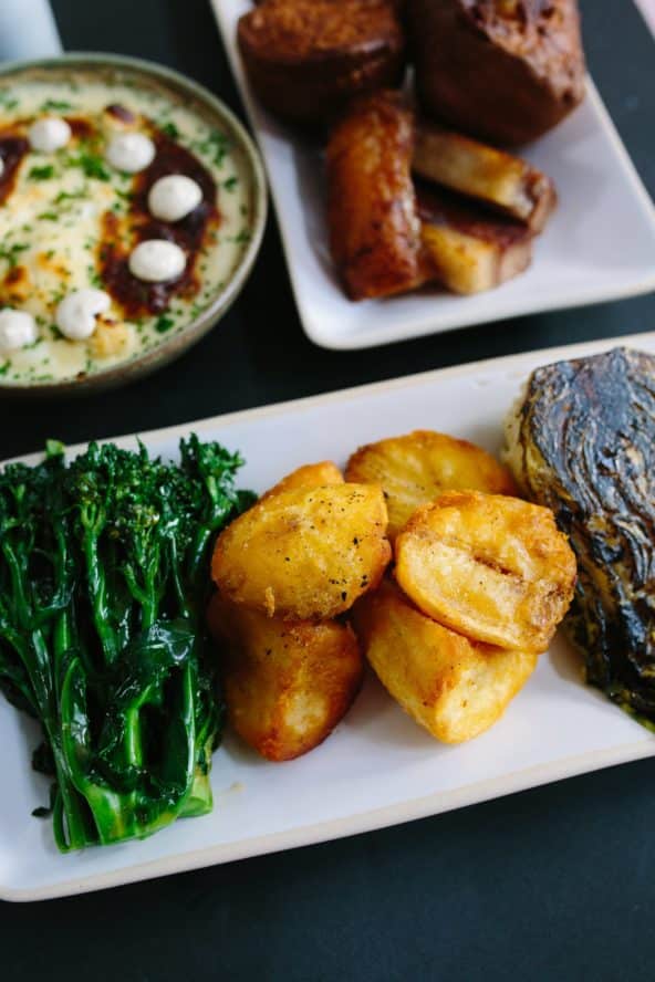 A close up of the roast potatoes, brocollini, and cabbage from the 12:51 sunday roast
