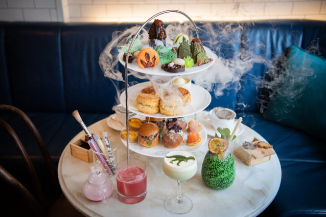 A delicious spread of cakes and sweet treats surrounded by fog at the Jurassic afternoon tea at The Ampersand hotel