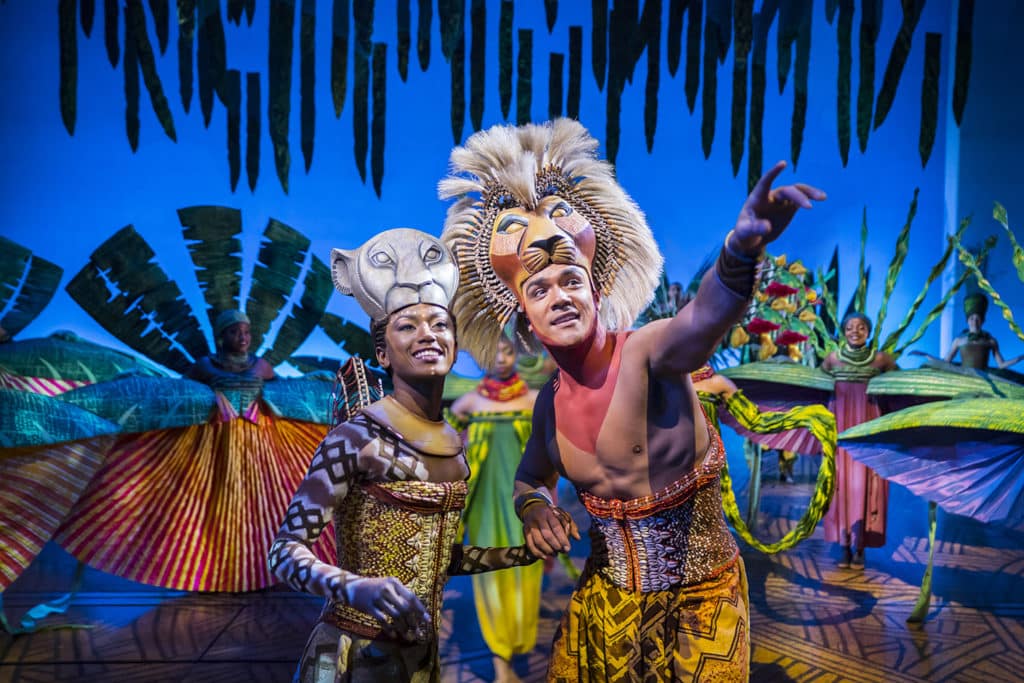 Two actors as Simba and Nala in Disney's The Lion King musical on stage