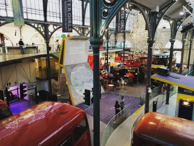 Buses and people milling around in London Transport Museum in Covent Garden