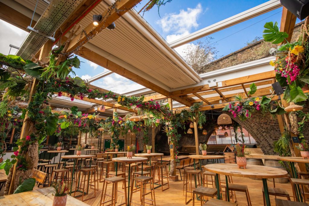 the lost in brixton rooftop bar, with an open awning above it revealing gorgeous blue sky