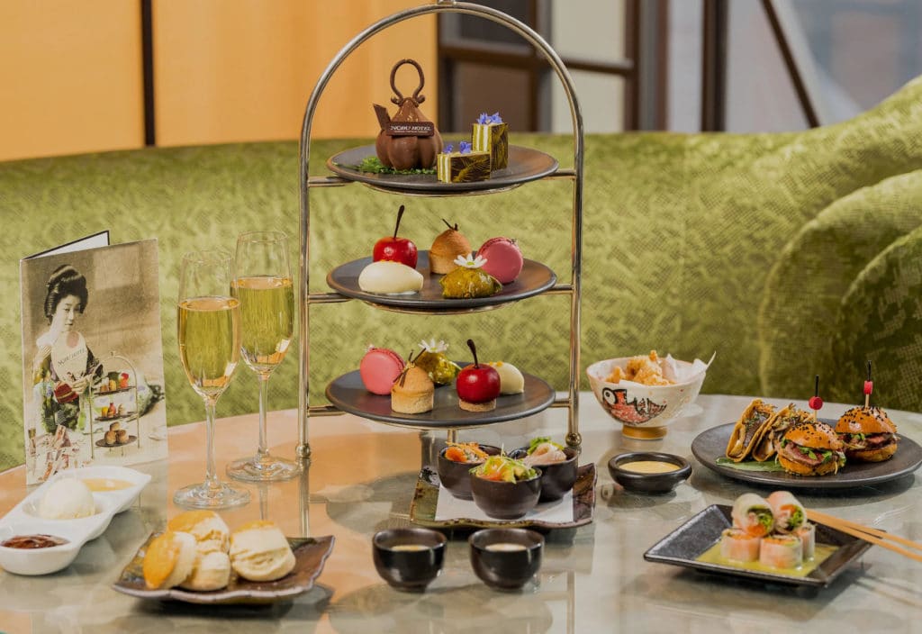 a spread of sweet and savoury dishes and flutes of champagne from the nobu hotel afternoon tea