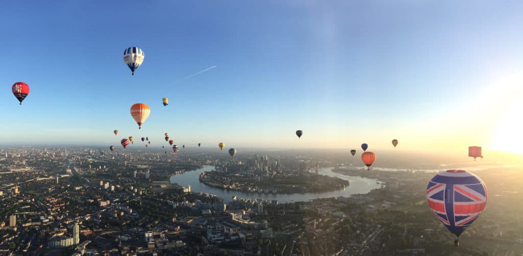 hot air balloons spread out in the sky above London