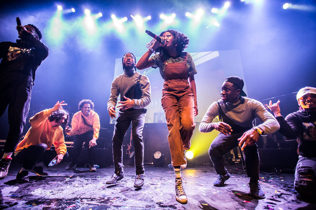 little simz performing onstage surrounded by other performers