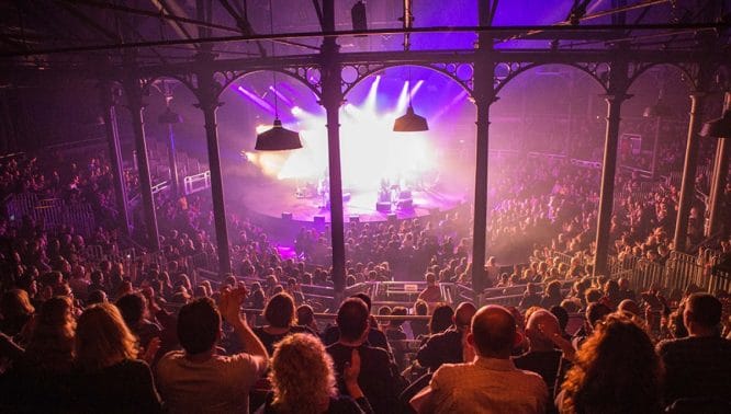 A large crowd enjoying watching some people on stage at the Roundhouse – one of the best things to do in Camden