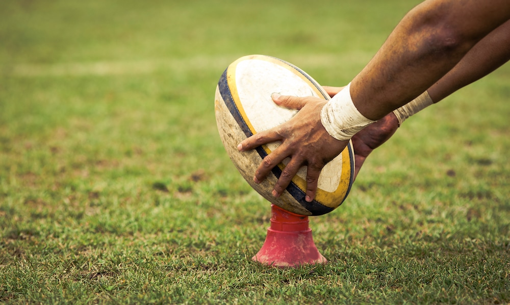 A rugby ball being prepared to be kicked