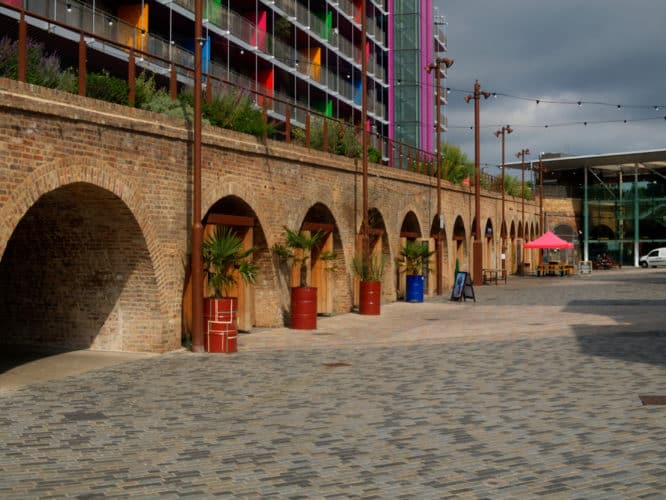 View of railway arches below Deptford train station with St Paul’s church tower in the distance