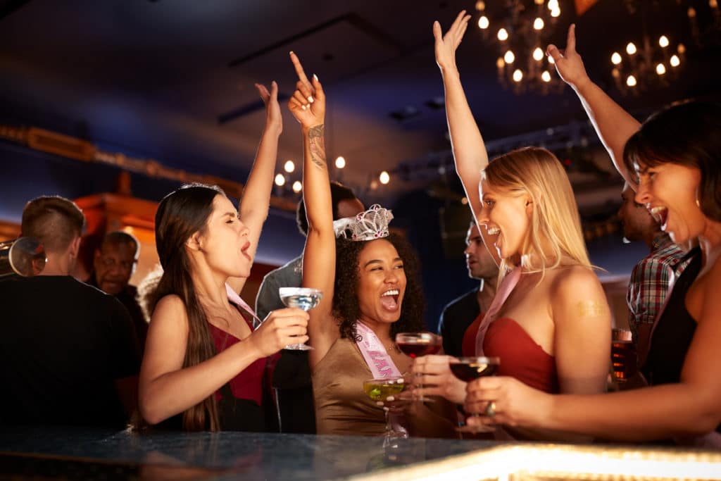 Four girls letting loose and dancing at a nightclub, one of the best hen do ideas in London