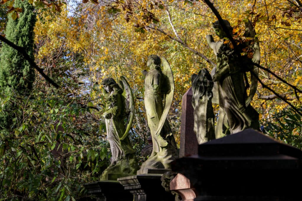 Some statues surrounded by ambient light at the Abney Park Cemetery in Stoke Newington