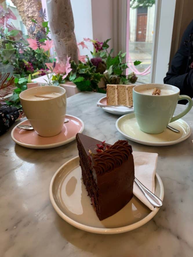 A delicious slice of chocolate cake and two coffees served at Peggy Porschen Cakes, one of the best cake shops in London