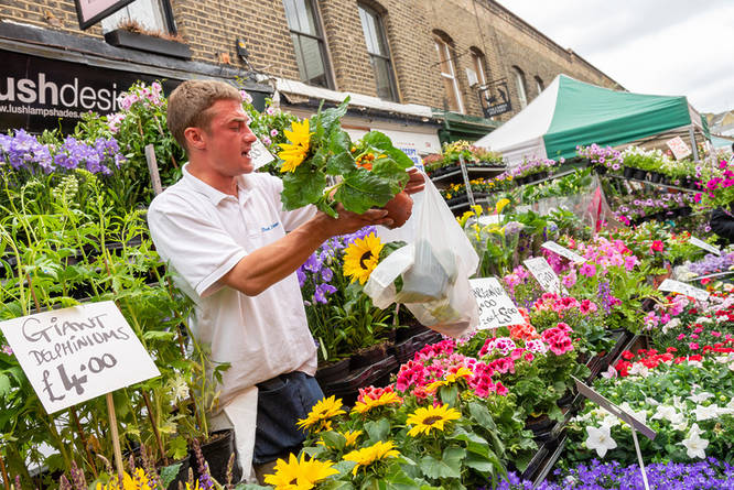 A man selling flowers and plants at Columbia Road Flower Market in East London