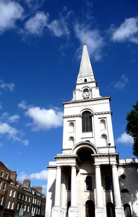 The towering spire of Christ Church Spitalfields in East London surrounded by blue skies