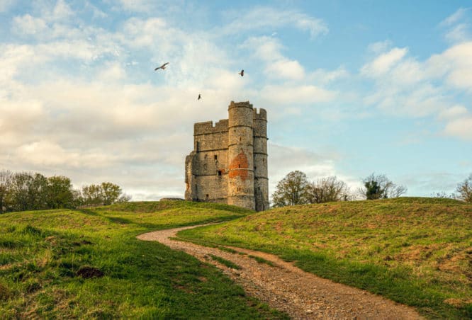The turret-type gatehouse of Donnington Castle in Berkshire near Newbury with three red kites circling