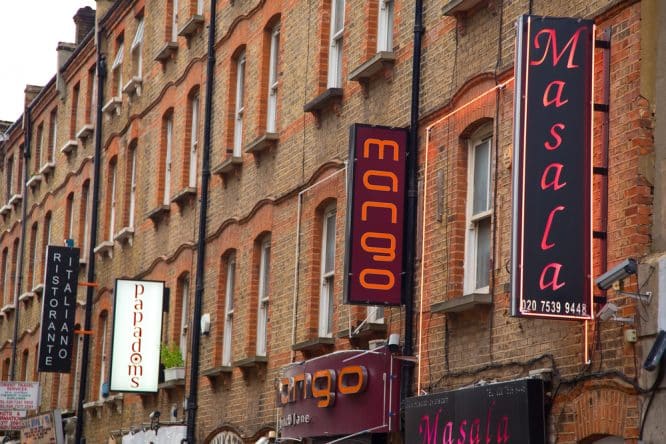 A selection of Indian restaurant signs hanging off walls in Brick Lane, London