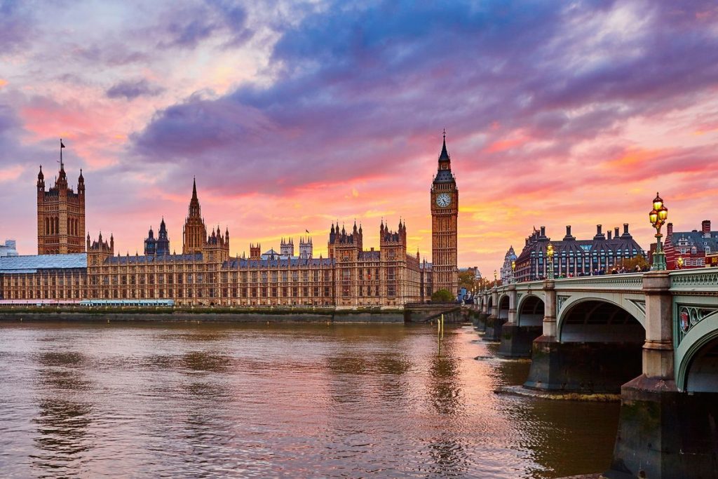 A sunset in front of the iconic Houses of Parliament and Big Ben in London, England