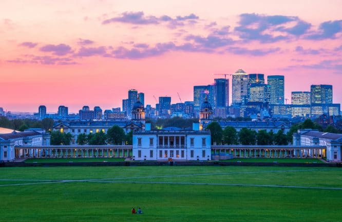 The sun setting over skyscrapers of Canary Wharf and Greenwich Park