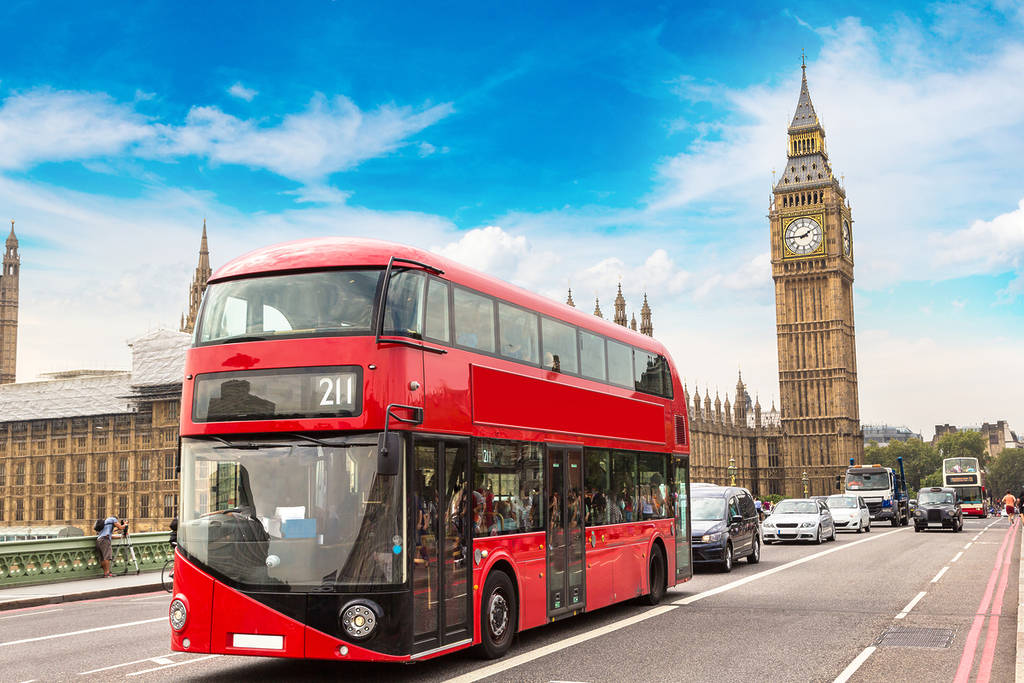 a red London bus crossing Westminster Bridge in front of Big Ben