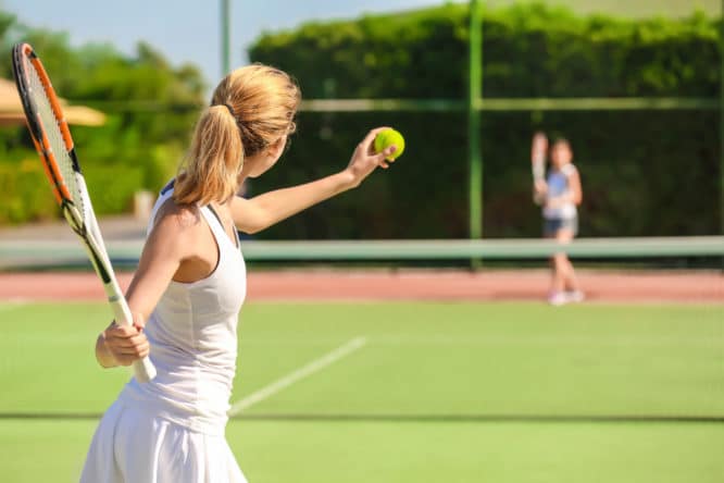 A woman playing a game of tennis at one of the best tennis courts in London