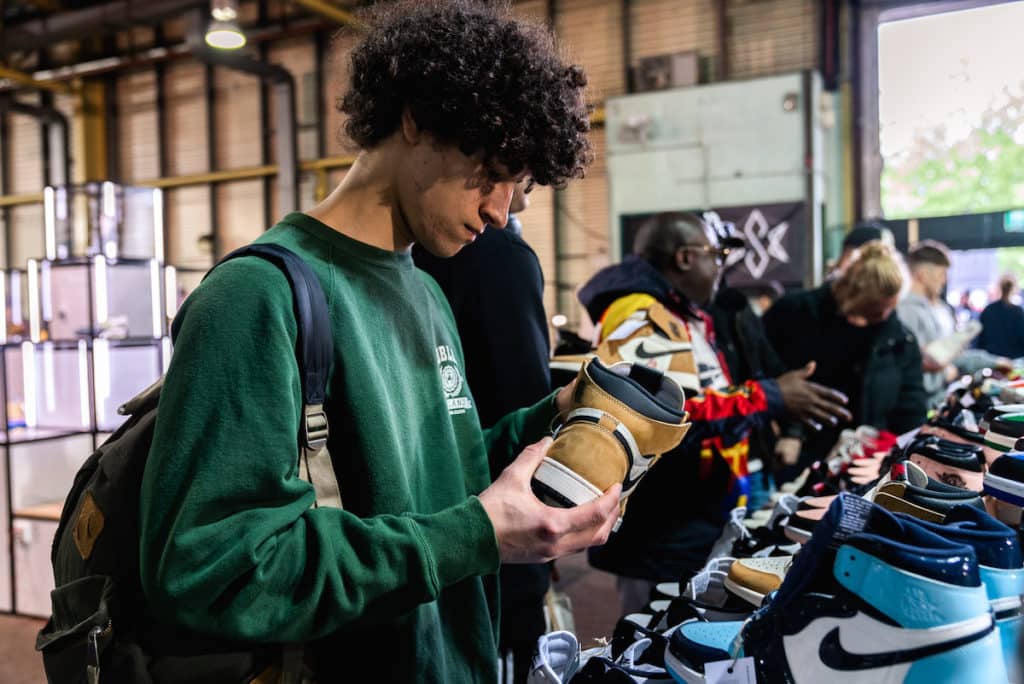 a young man looks at a sneaker