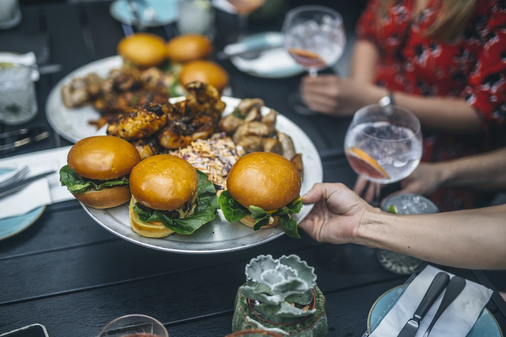 A selection of burgers and a spread of delicious food and drinks at Temper Restaurant