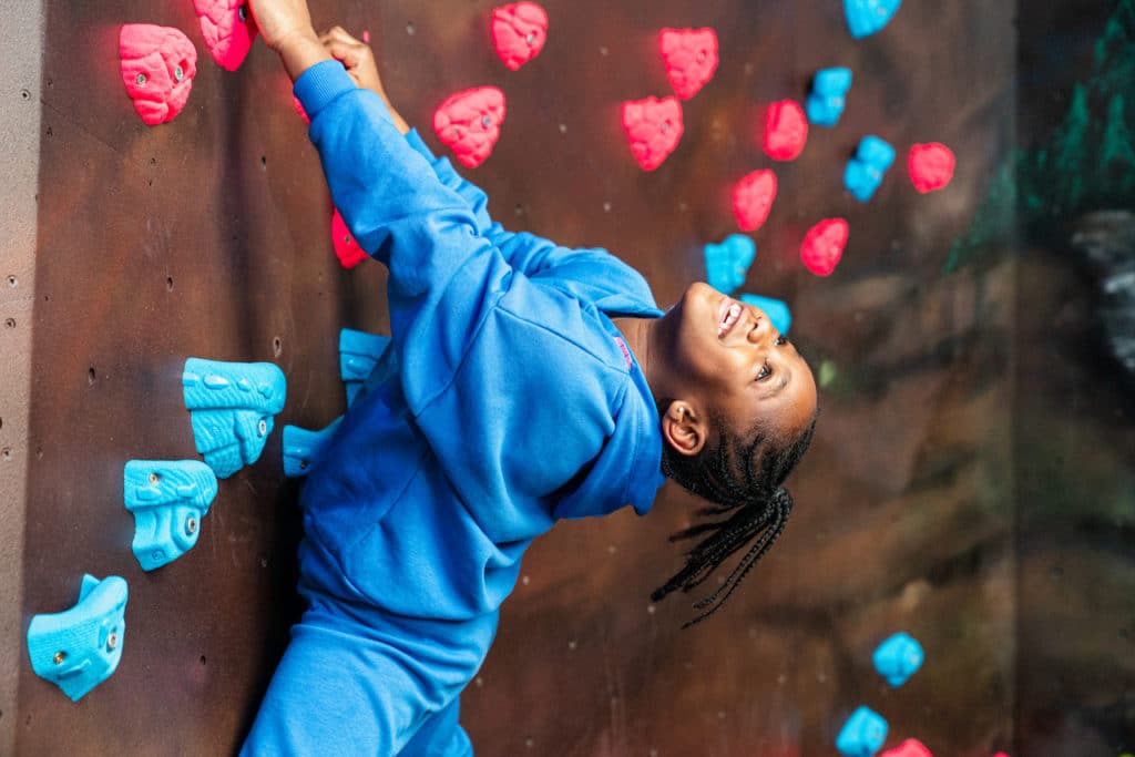 a child happily climbing a climbing wall at Substation Brixton