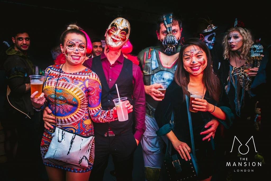 Four people enjoying themselves at a Halloween event in London called The Mansion