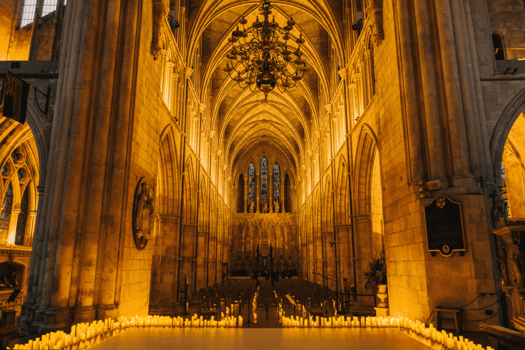 The inside of Southwark Cathedral in the glow of hundreds of flickering candles surrounding a stage for a Candlelight performance.