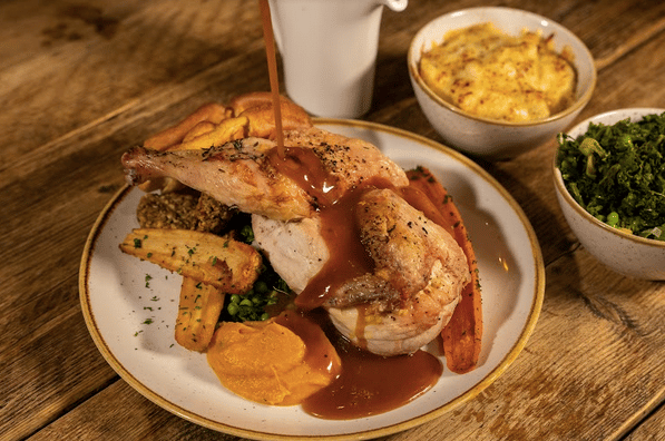 A delicious roast chicken being drizzled in gravy at The Farrier in Camden